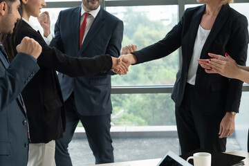 Business people handshake in corporate office showing professional agreement on a financial deal contract.