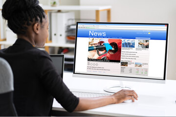 Wall Mural - African Woman Looking At News In Online Newspaper