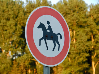 Sign forbids riding with a horse and a rider