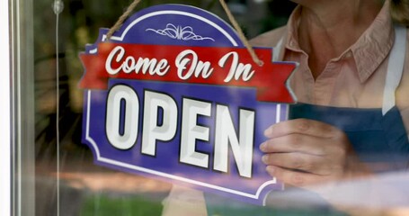 Wall Mural - 4k Female Shop Owner Flips Closed Sign To Open Ready for Business
