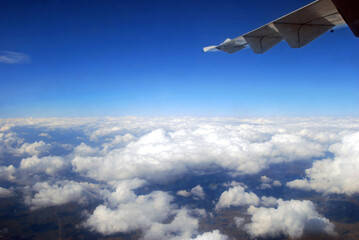 View of the wing of the airplane over the clouds in Romania.