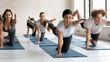 © fizkes - Focused happy mixed race young people doing bird dog pose with female indian ethnicity instructor, multiracial group practicing Parsva Balasana for posture improvement body balance at yoga class.