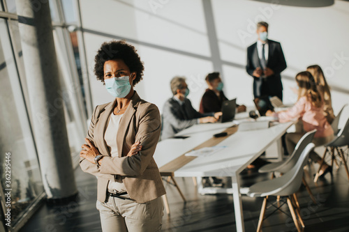 Obraz Dibond African American woman standing in office and wear mask as protection from corona virus