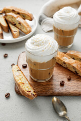 Wall Mural - Iced coffee latte with whipped cream and biscotti cookies in glass.