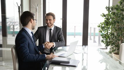 Wall Mural - Excited Caucasian male business partners handshake close deal make agreement after successful negotiation in office, smiling businessmen shake hands get acquainted at meeting, partnership concept