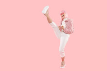 Women Power! Full Length Shot Of Young Energetic Girl Doing High Kick In Air While Dancing, Isolated On Pink Background