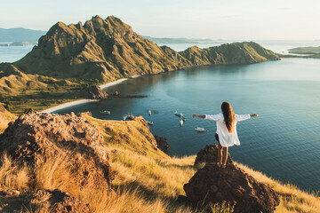 Woman with amazing view of Padar island in Komodo national park, Indonesia. Enjoying tropical vacation in Asia. Lifestyle travel concept. View from behind.