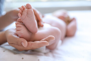 Wall Mural - Mother and her newborn baby on bed, closeup. Space for text