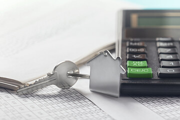 Real estate, keychain with house symbol. Calculator with finance blank.