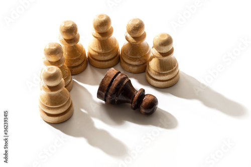 One black chess pawn among whites. Concept of racism and discrimination.