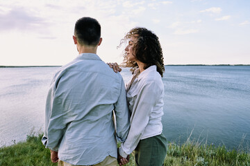 Canvas Print - Young serene female with dark curly hair standing close to her husband