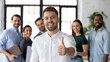 © fizkes - Smiling businessman company leader employee sales manager showing thumbs up smile looks at camera. Satisfied client pleased with service express positive feedback, recommendations like symbol concept