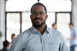 © fizkes - Head shot of african self-assured executive manager portrait, successful staff member company employee pose for camera photo shooting standing in office. Firm owner, proud founder, leadership concept