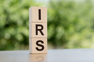 Wall Mural - IRS word written on wooden cubes on table with green background