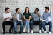 © fizkes - Multiracial men applicants sit on chairs in job interview queue show disrespect for girl kick out her. Disregard neglect, gender discrimination of women in business and professional occupation sphere