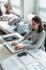 Focused woman working from home office on laptop