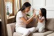 © fizkes - Bonding caring young beautiful vietnamese ethnicity mother involved in funny game with smiling adorable little asian daughter, playing patty cake or okie-dokey, enjoying relaxed daycare time indoors.
