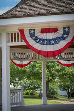 Traditional Patriotic  Independence Day Stars And Stripes Bunting Decorating A Gazebo On A Quaint New England Village Green.