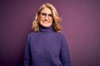 © Krakenimages.com - Middle age beautiful blonde woman wearing casual purple turtleneck sweater and glasses with a happy and cool smile on face. Lucky person.