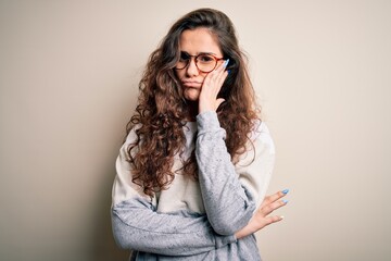 Sticker - Young beautiful woman with curly hair wearing sweater and glasses over white background thinking looking tired and bored with depression problems with crossed arms.