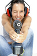A woman with headphone holding a driller like holding a gun