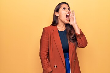 Poster - Young beautiful brunette woman wearing elegant jacket shouting and screaming loud to side with hand on mouth. communication concept.