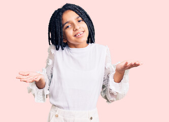 Canvas Print - Cute african american girl wearing casual white tshirt clueless and confused expression with arms and hands raised. doubt concept.