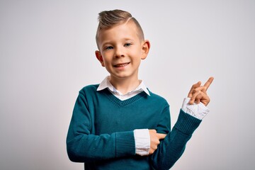 Wall Mural - Young little caucasian kid with blue eyes standing wearing elegant clothes over isolated background with a big smile on face, pointing with hand and finger to the side looking at the camera.