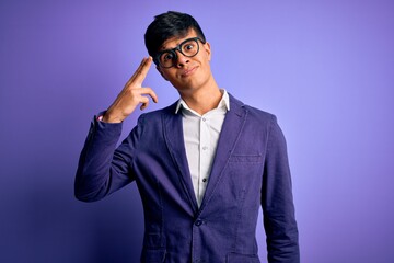 Poster - Young handsome business man wearing jacket and glasses over isolated purple background Shooting and killing oneself pointing hand and fingers to head like gun, suicide gesture.