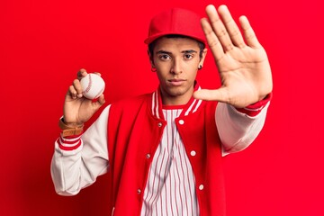 Wall Mural - Young african amercian man wearing baseball uniform holding ball with open hand doing stop sign with serious and confident expression, defense gesture