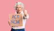 © Krakenimages.com - Senior grey-haired woman holding act now banner annoyed and frustrated shouting with anger, yelling crazy with anger and hand raised