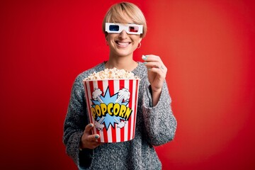 Poster - Young blonde woman with short hair wearing 3d movie glasses and eating popcorn at the cinema with a happy face standing and smiling with a confident smile showing teeth