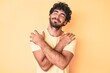 © Krakenimages.com - Handsome young man with curly hair and bear wearing casual tshirt over yellow background hugging oneself happy and positive, smiling confident. self love and self care
