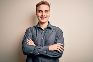 Wall Mural - Young handsome redhead man wearing casual shirt standing over isolated white background happy face smiling with crossed arms looking at the camera. Positive person.