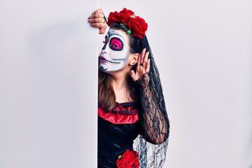 Sticker - Young woman wearing day of the dead custome holding blank empty banner smiling with hand over ear listening an hearing to rumor or gossip. deafness concept.