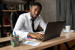 © shunevich - Handsome african business man working wirh laptop in modern office