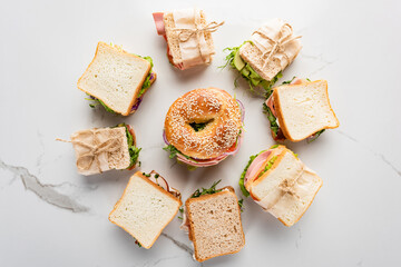 Wall Mural - top view of fresh sandwiches around bagel on marble white surface