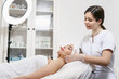 © ANR Production - Beautician performs facial massage for a young woman in a beauty clinic or spa salon. Cosmetology treatment. Perfect skin concept. Eternal youth.