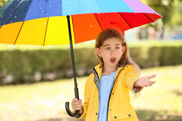 Sticker - Cute little girl with umbrella wearing raincoat in park