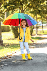 Sticker - Cute little girl with umbrella wearing raincoat in park