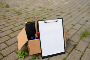 Paper tablet on the background of a box with stationery on cobblestones.