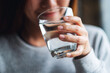 canvas print picture - Closeup image of a beautiful young asian woman holding a glass of water to drink