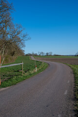 Wall Mural - An empty rural road that winds through the Scanian landscape in southern Sweden