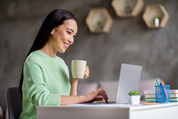 Poster - Profile side photo of smart chinese girl ceo expert sit desk work remote laptop texting typing report hold beverage mug in house indoors