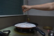© deep - sprinkling indian spices masala on hot dosa with hands on non stick pan