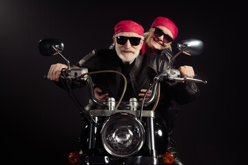 Canvas Print - Photo of two cool old bikers grey hair man lady couple drive vintage chopper traveling together feel young wear rocker leather jacket outfit bandana isolated black color background