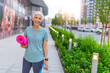 © Dragana Gordic - Portrait of a senior sportswoman with exercise mat in the park. Happy active senior woman. Beautiful sports lady. Happy mature woman with a yoga mat. Woman With Rolled Up Exercise Mat.