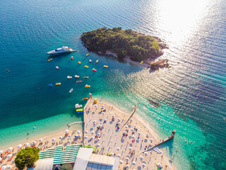 Wall Mural - Aerial view of a beautiful white sand beach with turquoise water and relaxing people on a sunny day. Ksamil, Albania.