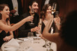 © Jacob Lund - Group of friends toasting champagne at dinner party
