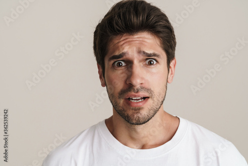 Fotomural Portrait of scared unshaven man expressing surprise on camera